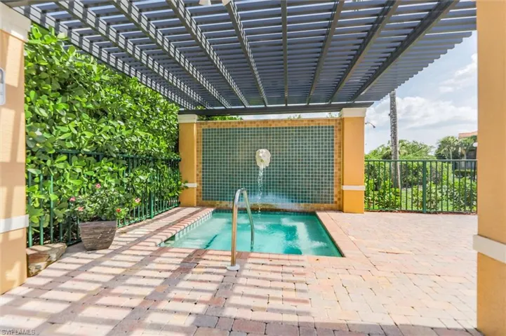 View of pool with a pergola and a patio