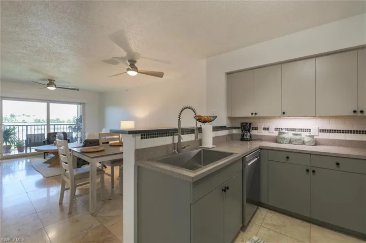 Kitchen with kitchen peninsula, ceiling fan, and gray cabinetry