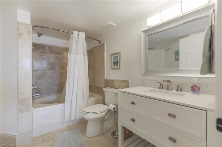 Full bathroom featuring toilet, vanity, tile patterned flooring, and shower / tub combo
