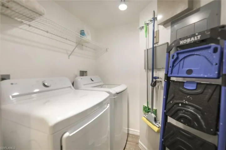 Laundry room with wood-type flooring and washer and clothes dryer