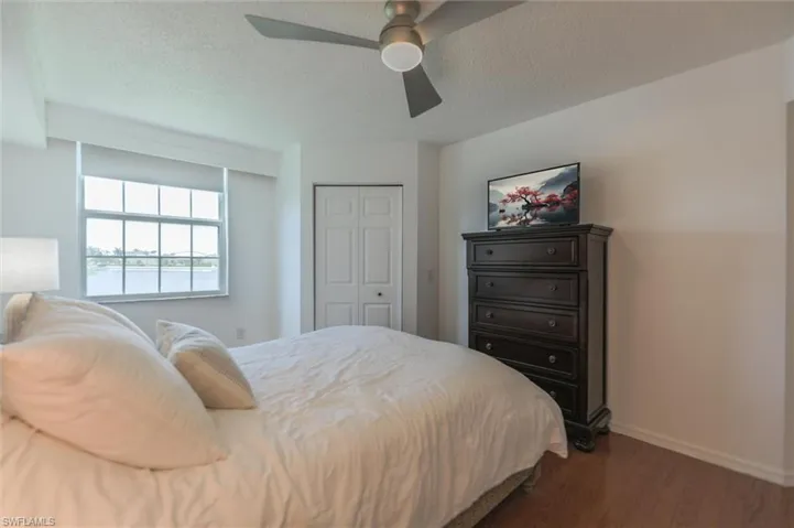 Bedroom with wood-type flooring, a textured ceiling, a closet, and ceiling fan