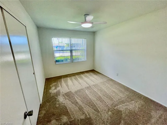 Empty room featuring carpet flooring and ceiling fan