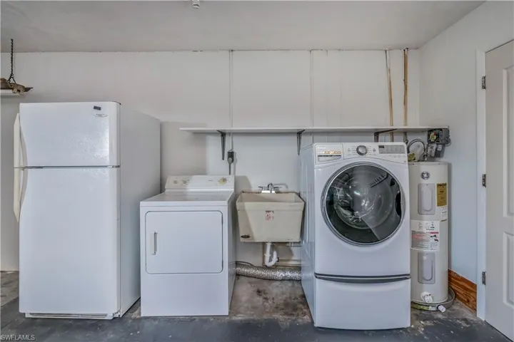 Garage with refrigerator/freezer, independent washer and dryer, electric water heater, and sink