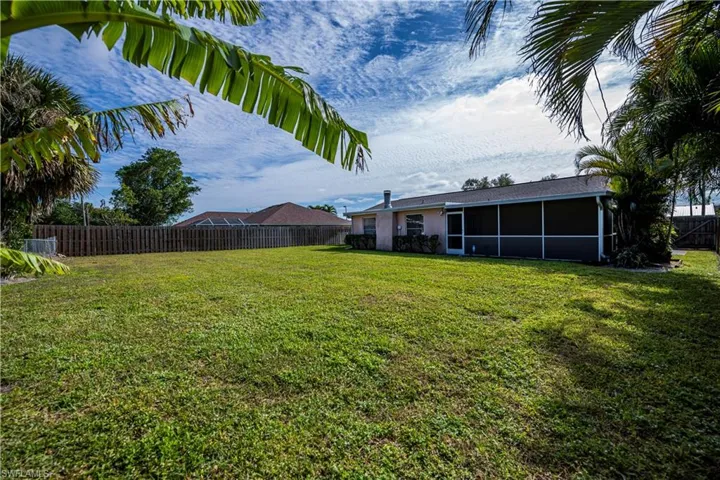 View of fenced in yard featuring a sunroom