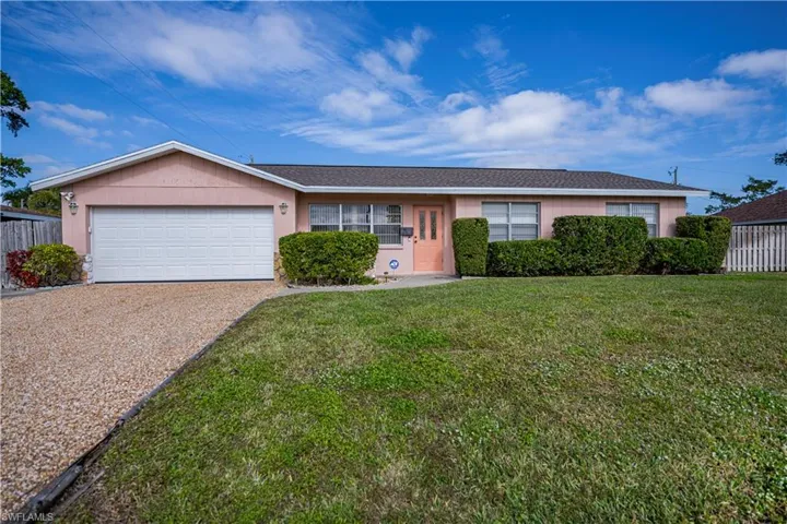 Ranch-style house with a garage and a front lawn