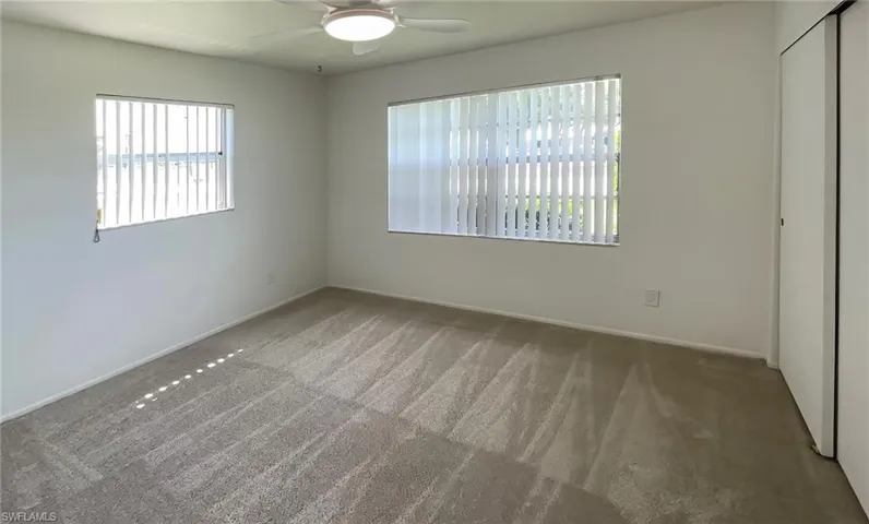 Unfurnished bedroom featuring carpet flooring and ceiling fan