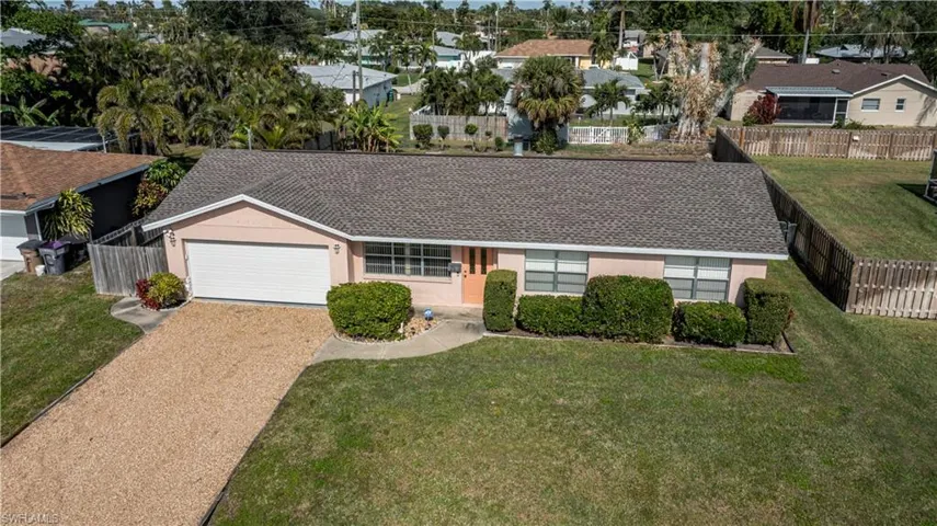 Single story home with a garage and a front lawn