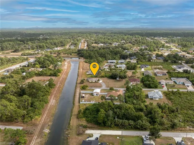 Aerial view of property and surrounding area with a forest