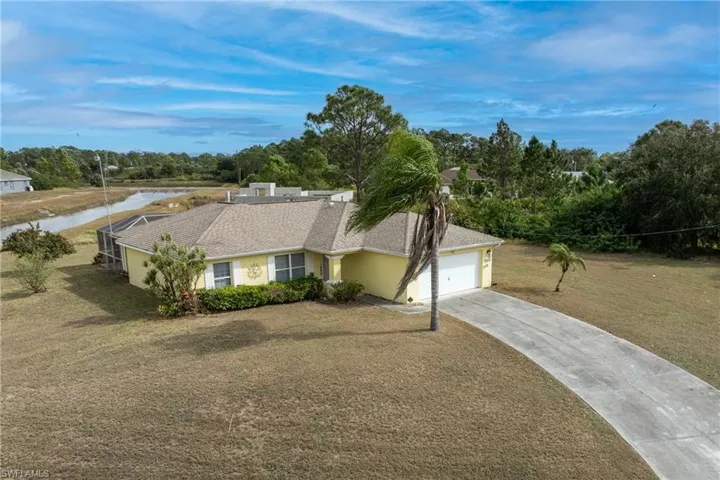Single story home with a front yard, concrete driveway, stucco siding, a garage, and roof with shingles