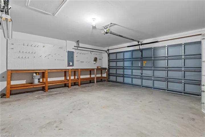 Garage featuring electric panel and a garage door opener