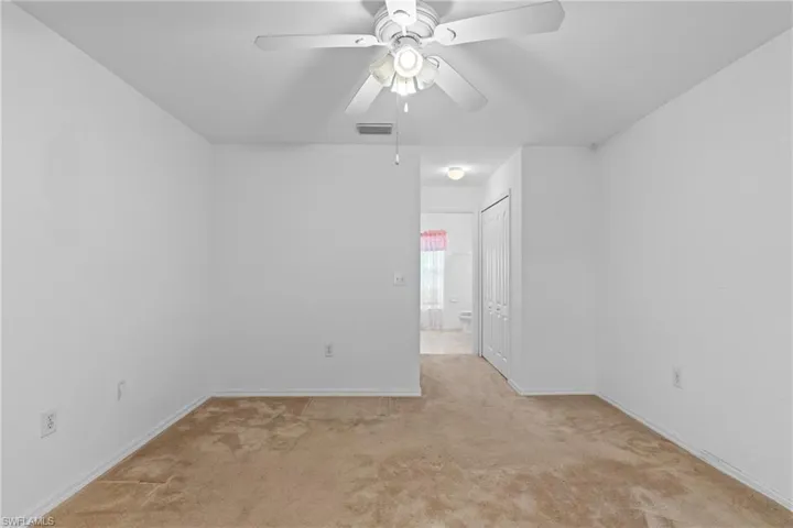 Spare room featuring light colored carpet and ceiling fan