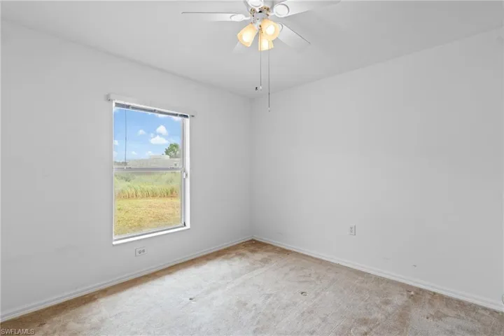 Unfurnished room featuring carpet flooring and ceiling fan