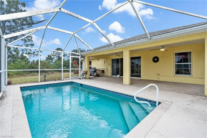 Swimming pool with a patio, a sunroom, and a lanai