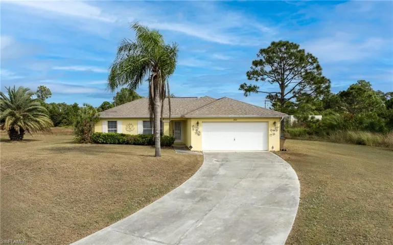 Single story home with concrete driveway, a garage, a front lawn, and stucco siding