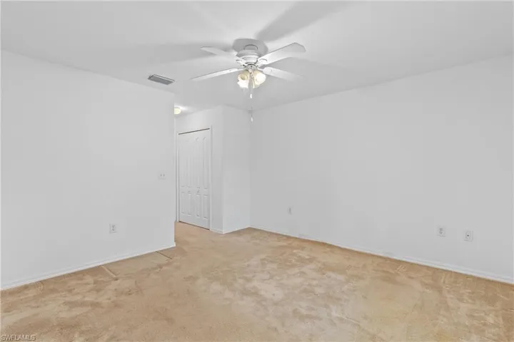 Unfurnished room with a ceiling fan and light colored carpet