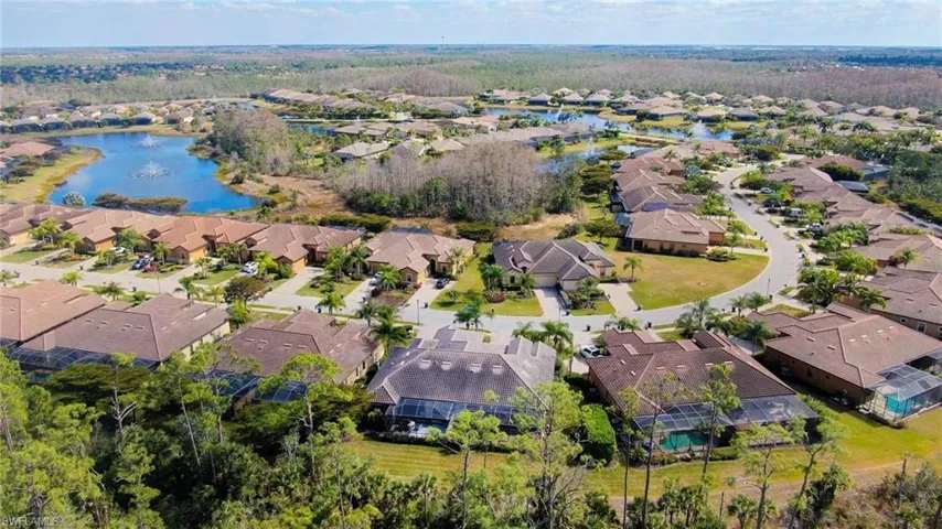 Aerial view of property and surrounding area featuring a nearby body of water and nearby suburban area