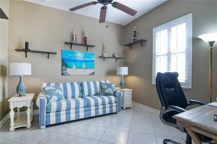 Office area with a ceiling fan and tile patterned flooring