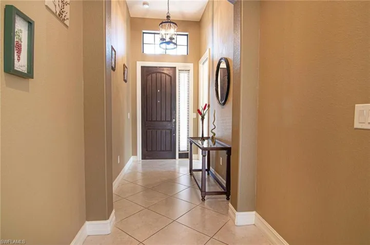 Entryway with tile patterned flooring, a high ceiling, and a chandelier