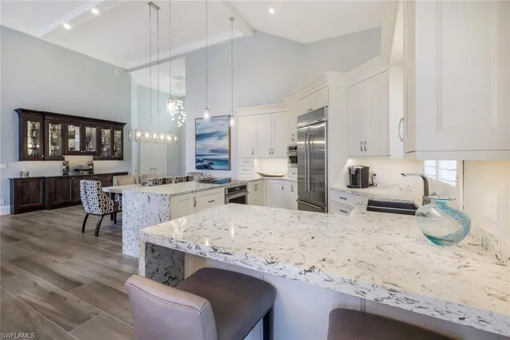 Kitchen with kitchen peninsula, stainless steel appliances, pendant lighting, and a breakfast bar