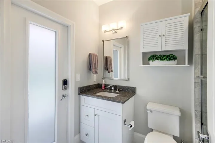 Bathroom with vanity, toilet, and a shower with door