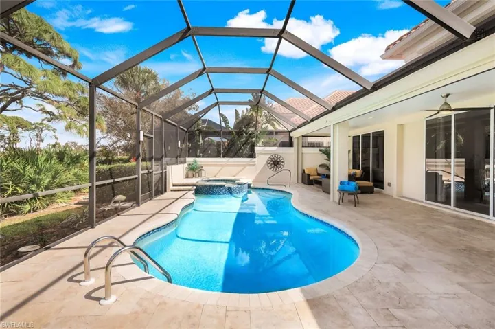 View of swimming pool with a patio area, ceiling fan, an in ground hot tub, and glass enclosure