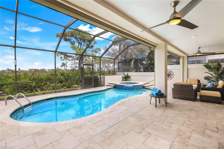 View of swimming pool with an in ground hot tub, ceiling fan, a lanai, and a patio