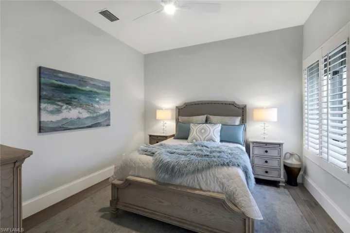 Bedroom featuring multiple windows, dark hardwood / wood-style floors, and ceiling fan