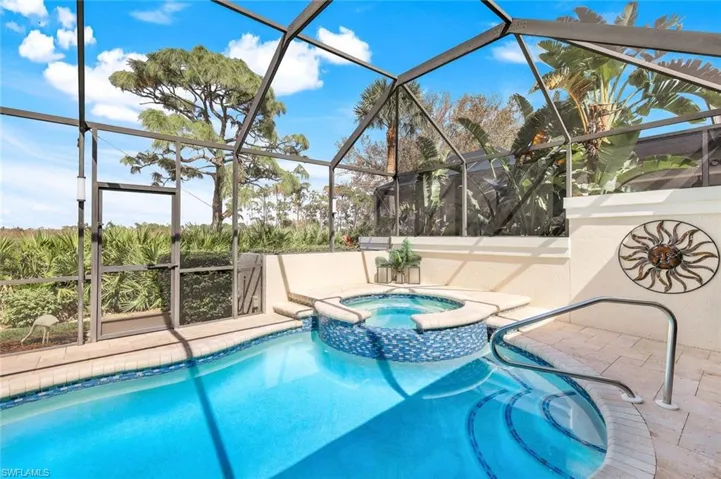 View of pool featuring a patio area, a lanai, and an in ground hot tub