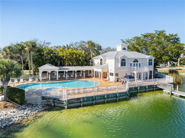 Back of house featuring a metal roof, a patio area, a community pool, and a gazebo