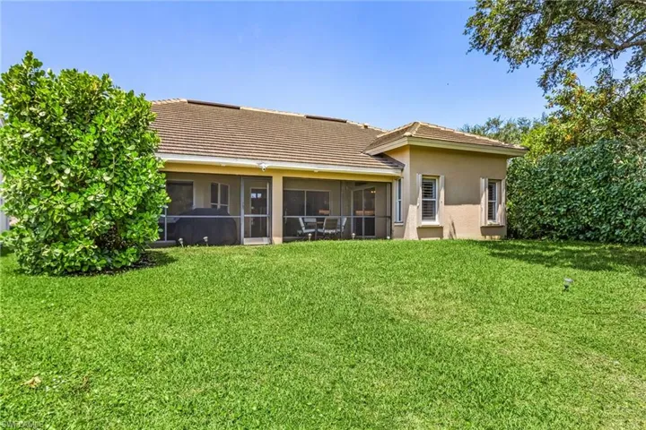 Back of property featuring a sunroom and a lawn