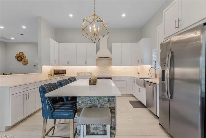 Kitchen featuring a center island, stainless steel appliances, backsplash, and custom exhaust hood