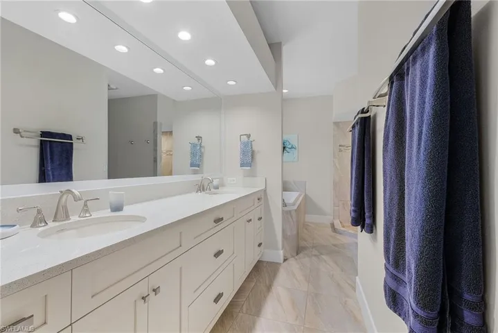Bathroom featuring tile floors, oversized vanity, and dual sinks