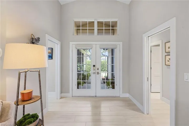 Entryway featuring high vaulted ceiling, light hardwood / wood-style floors, and french doors