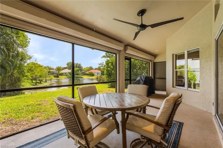 Sunroom / solarium featuring ceiling fan and a water view