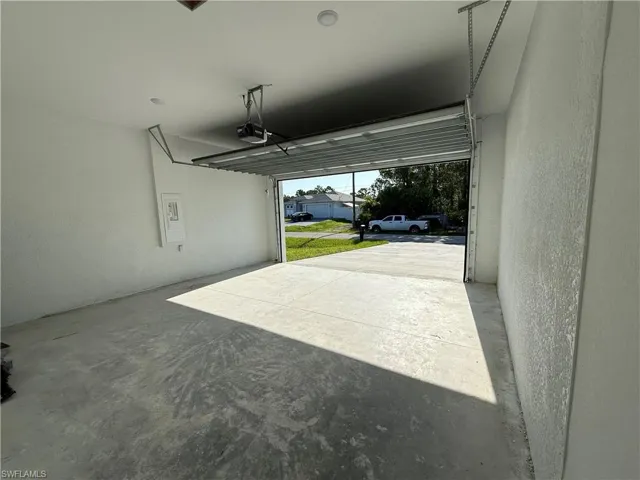 Garage with a textured wall and a garage door opener