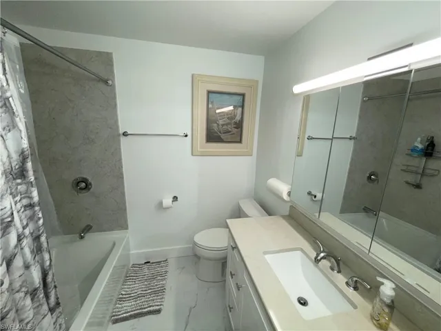 Full bathroom with shower / bath combination with curtain, vanity, and toilet