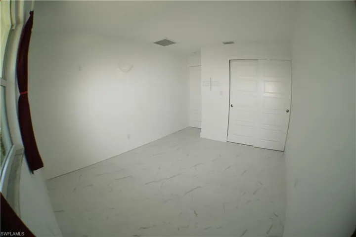 Unfurnished room featuring baseboards, visible vents, and marble finish floor