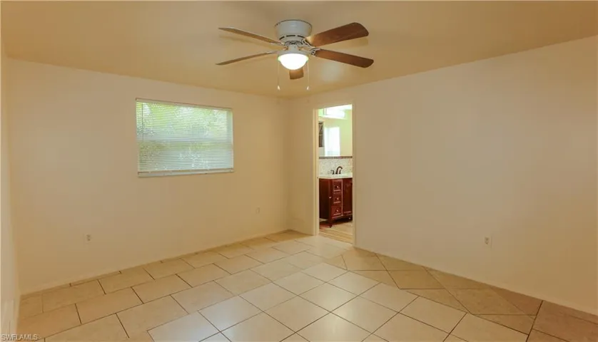 Empty room with light tile patterned floors and ceiling fan