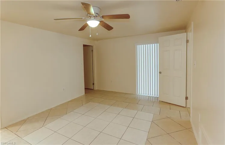 Unfurnished room with light tile patterned floors and ceiling fan