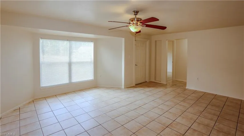Empty room featuring a ceiling fan and light tile patterned floors