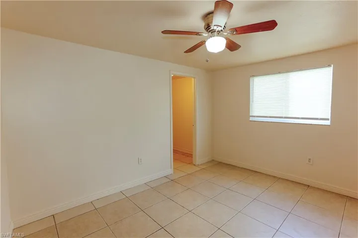 Empty room featuring ceiling fan and light tile patterned flooring