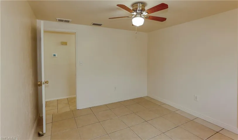 Unfurnished room featuring ceiling fan and light tile patterned floors