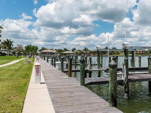 Dock area with a water view and a lawn