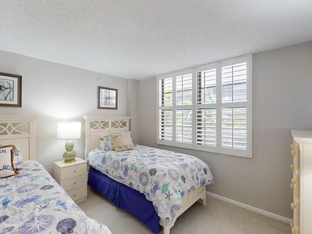Bedroom featuring a textured ceiling and light colored carpet