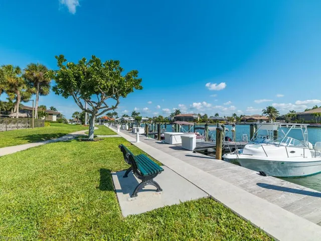 View of dock with a lawn and a water view