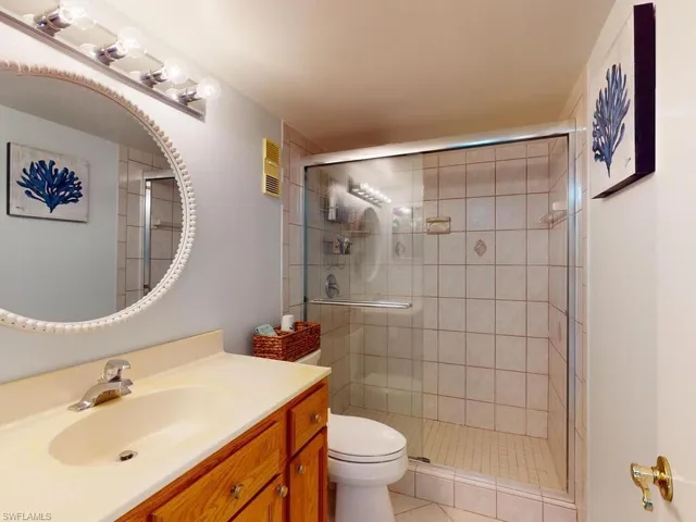 Bathroom with vanity, toilet, and a shower with door