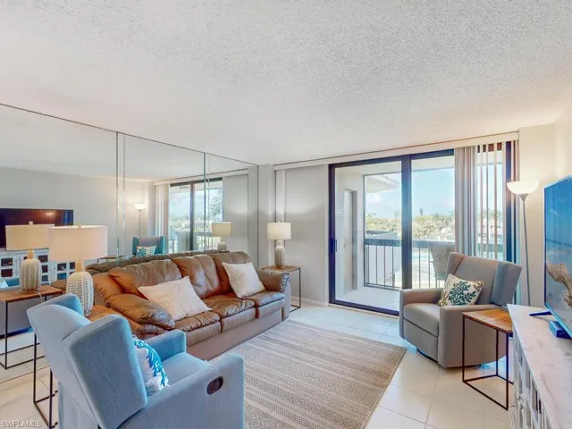 Living room with a wealth of natural light, light tile patterned flooring, and a textured ceiling