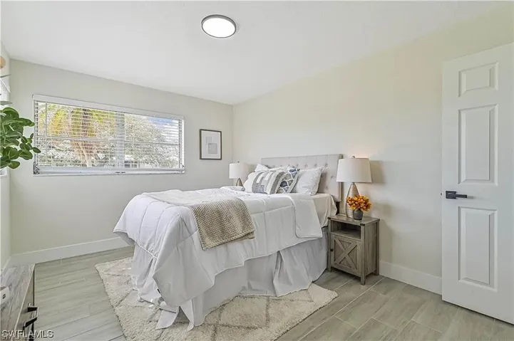 This room features light-colored walls and a window with blinds, allowing for natural light