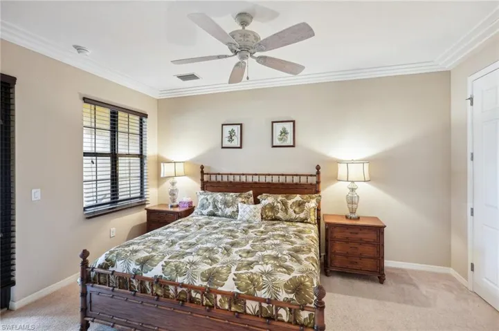 Bedroom featuring light carpet, ceiling fan, and crown molding