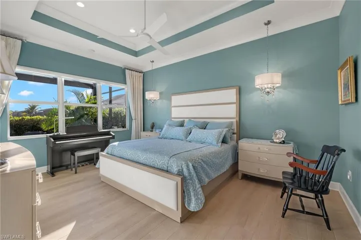 Elegant chandeliers, tray ceiling and brand new LVP flooring are part of this spacious primary bedroom!